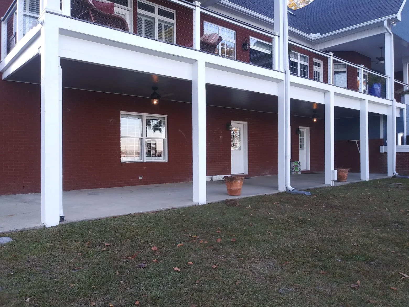 White aluminum under deck system with concrete floor and recessed lighting beneath residential deck