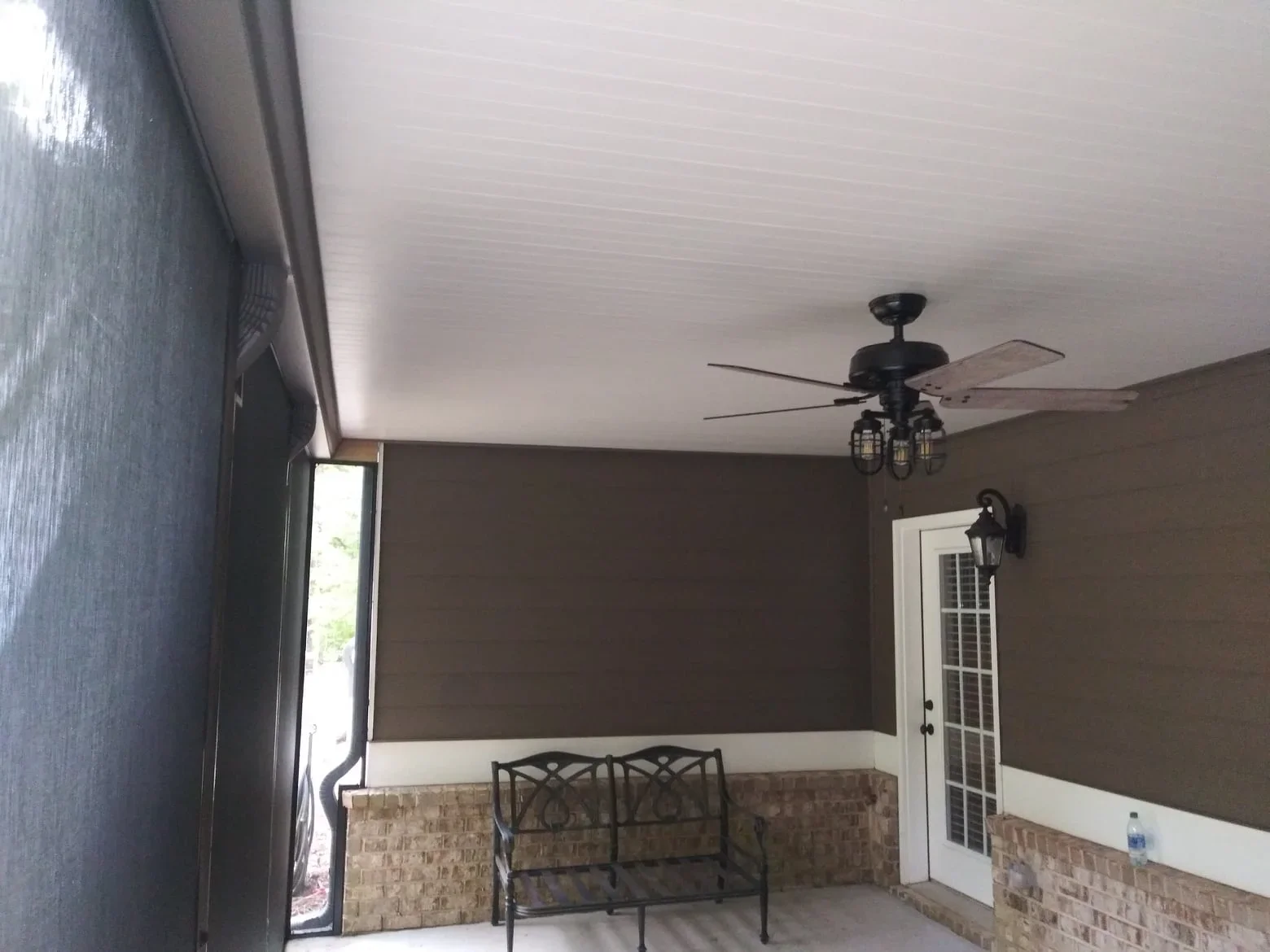 Under deck system with brown and cream painted walls, ceiling fan, and brick base