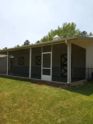 Black screen room with X-pattern panels and covered porch on residential property