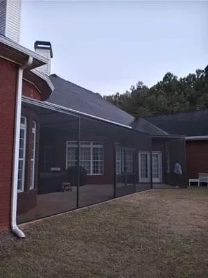 Black screen room addition attached to brick home with gabled roof in Conyers