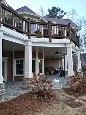 Two-story home with upper deck screen room and lower covered patio with ceiling fan