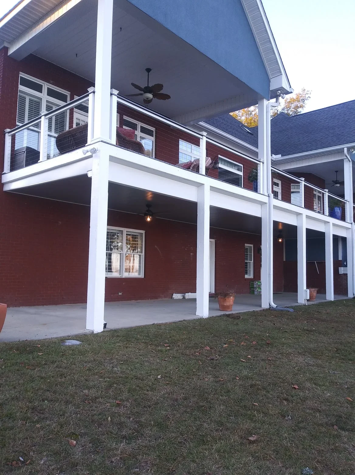 Two-story deck with white posts and under-deck drainage system creating covered patio below