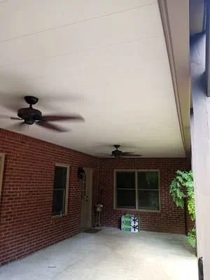 White ceiling screen room with fans over brick patio attached to brick home