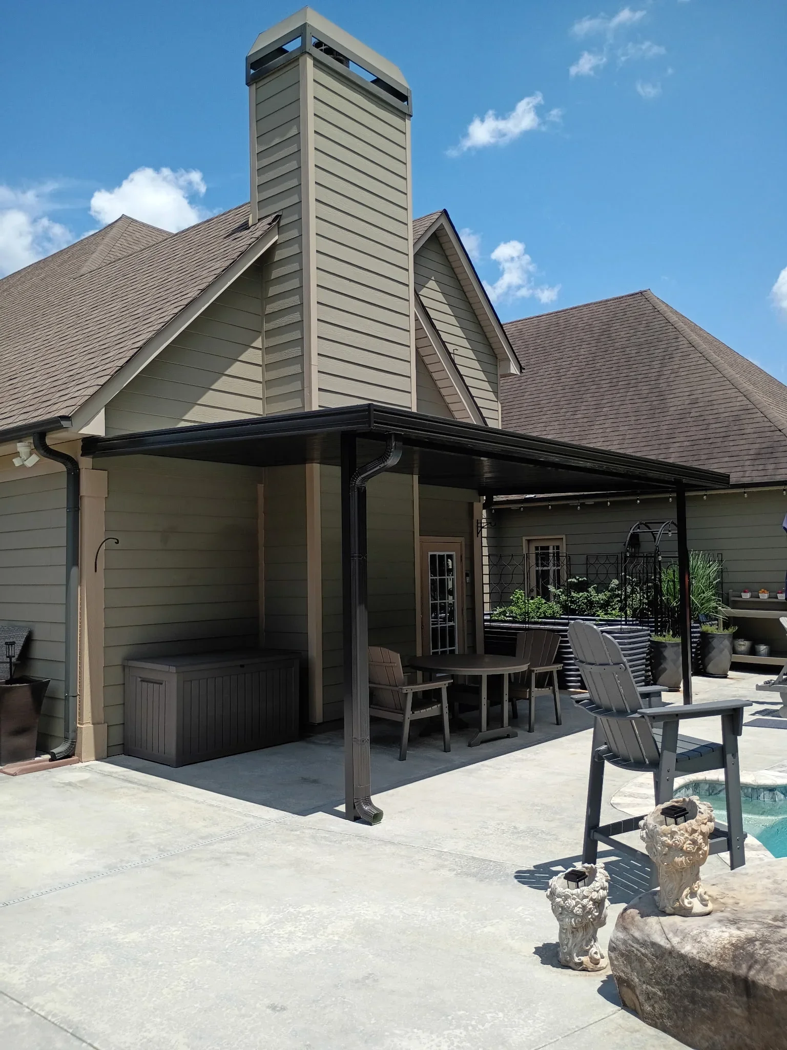 Black aluminum patio cover with attached screen room, concrete patio, modern residential design