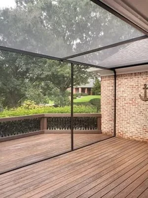 Screened deck with retractable shade canopy and composite decking overlooking trees