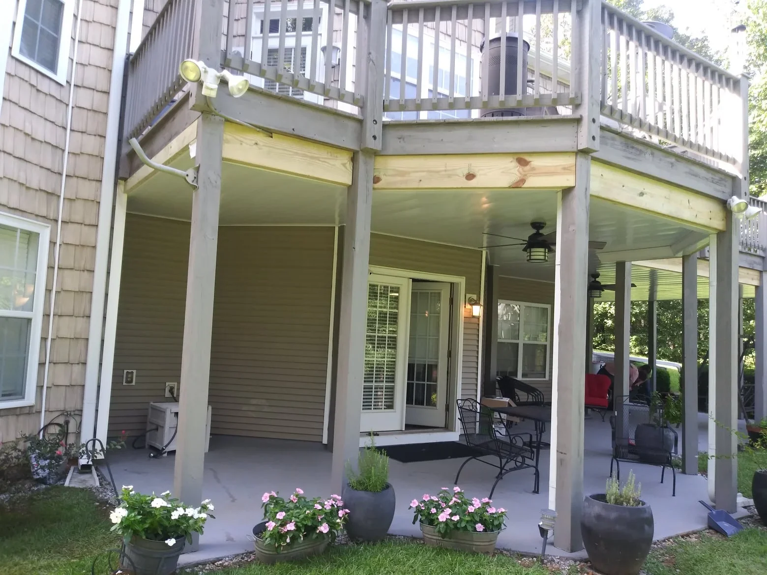 Under-deck system with white posts and ceiling beneath elevated composite deck