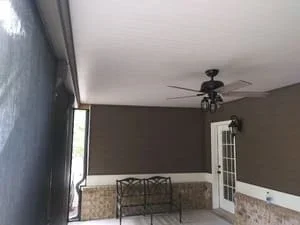 Interior view of completed screen room with ceiling fan and white trim framing