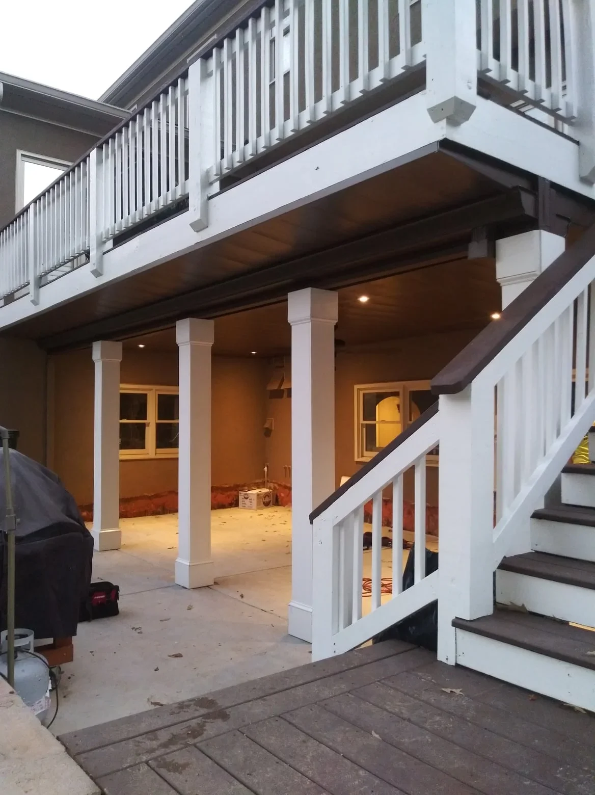 Aluminum under-deck system with white support columns, recessed lighting, and covered patio space