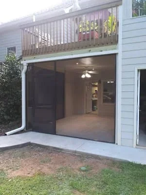Modern screen room with dark sliding door and aluminum frame attached to home